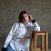 Cleo white shirt with double crochet collar worn sitting on floor