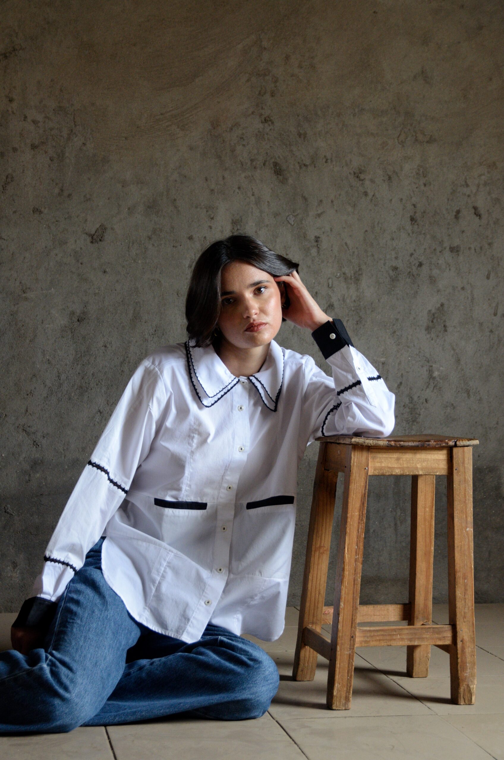 Cleo white shirt with double crochet collar worn sitting on floor