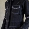 Détail de la veste Lova noire en denim avec surpiqûres contrastées blanches et finitions