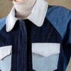Detail of the Doria jacket in blue patchwork denim showing contrast paneling