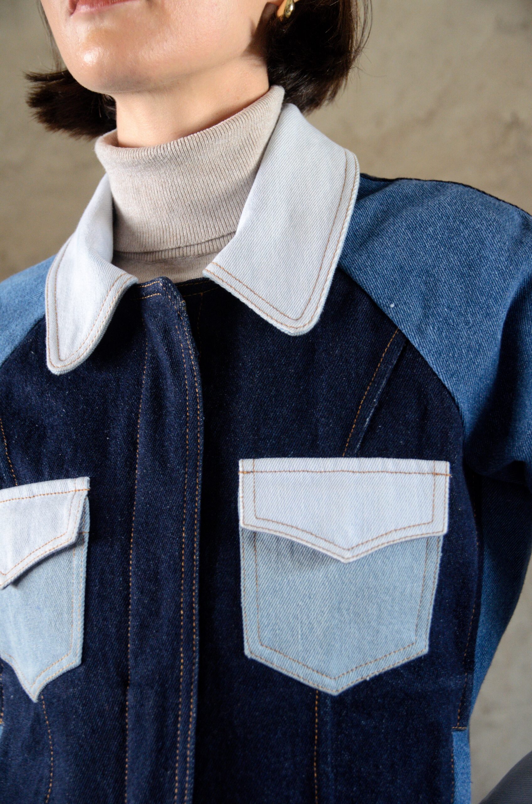 Detail of the Doria jacket in blue patchwork denim showing contrast paneling