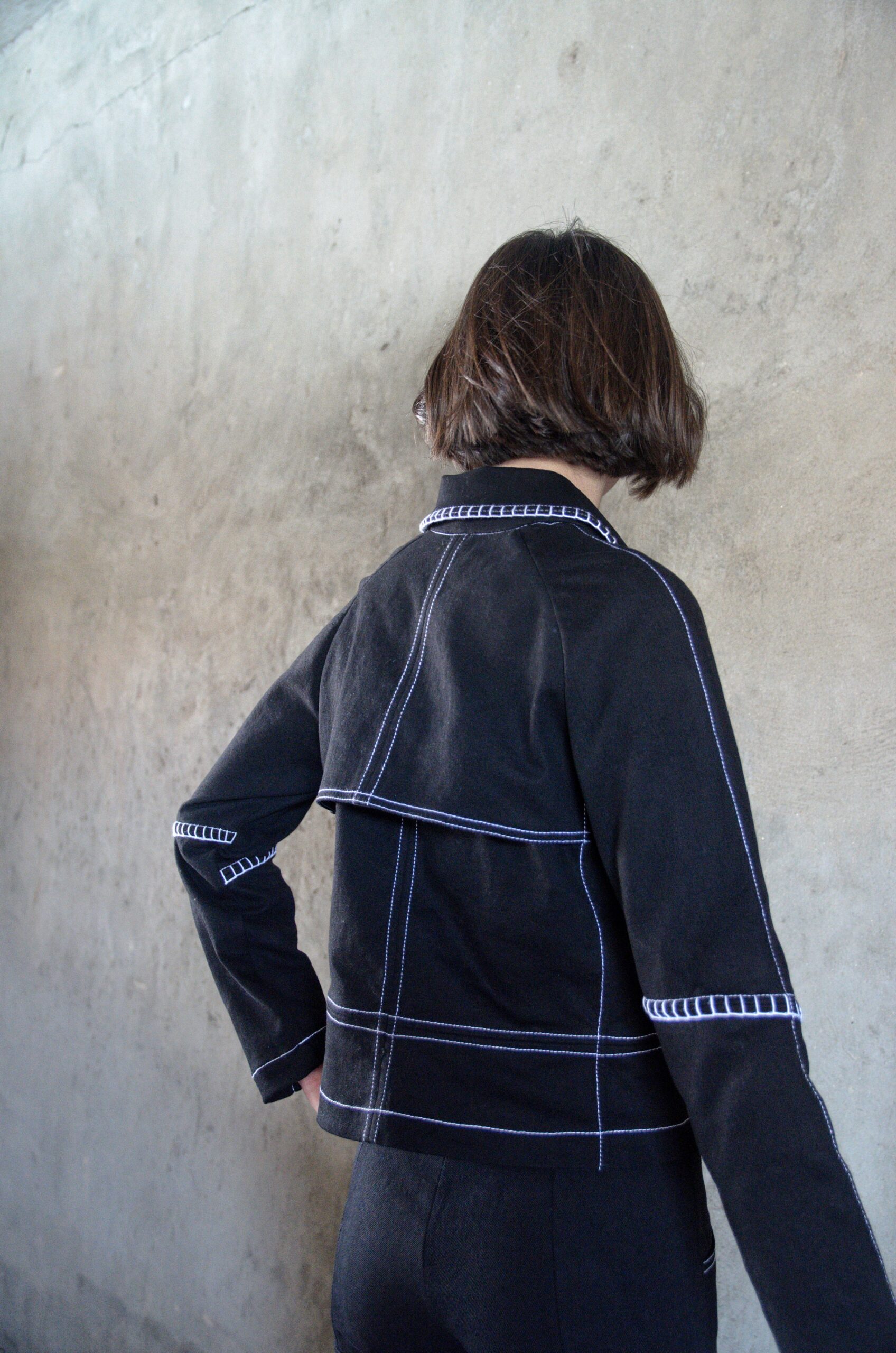 Veste Lova noire en denim vue de dos avec surpiqûres contrastées blanches