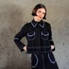 Veste Lova noire en denim avec surpiqûres contrastées blanches portée par un mannequin