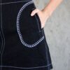 Detail of the Tantely skirt in black denim with hand-crocheted white cotton pocket