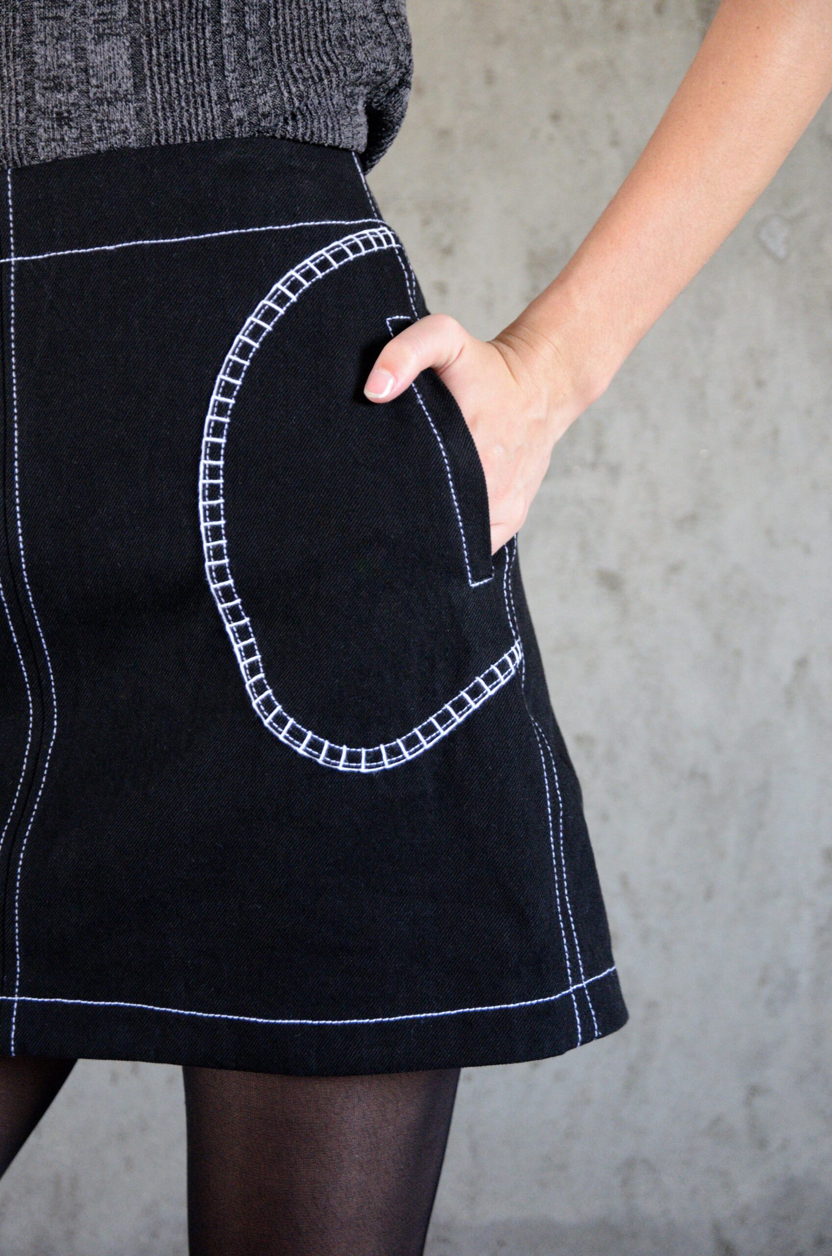 Detail of the Tantely skirt in black denim with hand-crocheted white cotton pocket