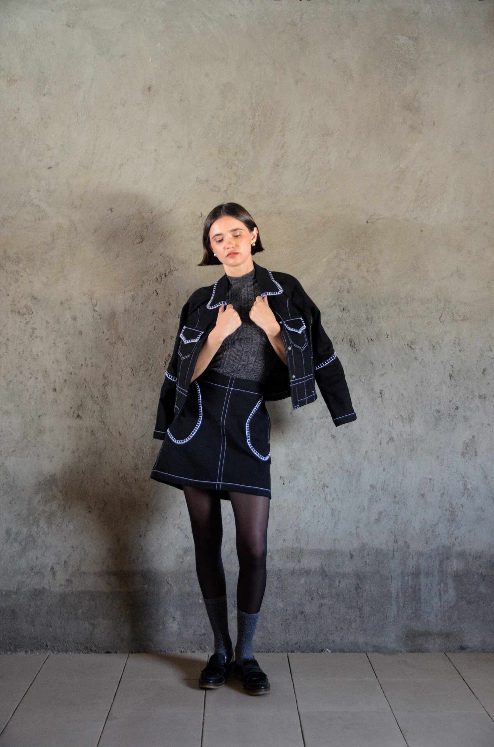 Tantely skirt in black denim worn in a full silhouette with contrast stitching and crochet details